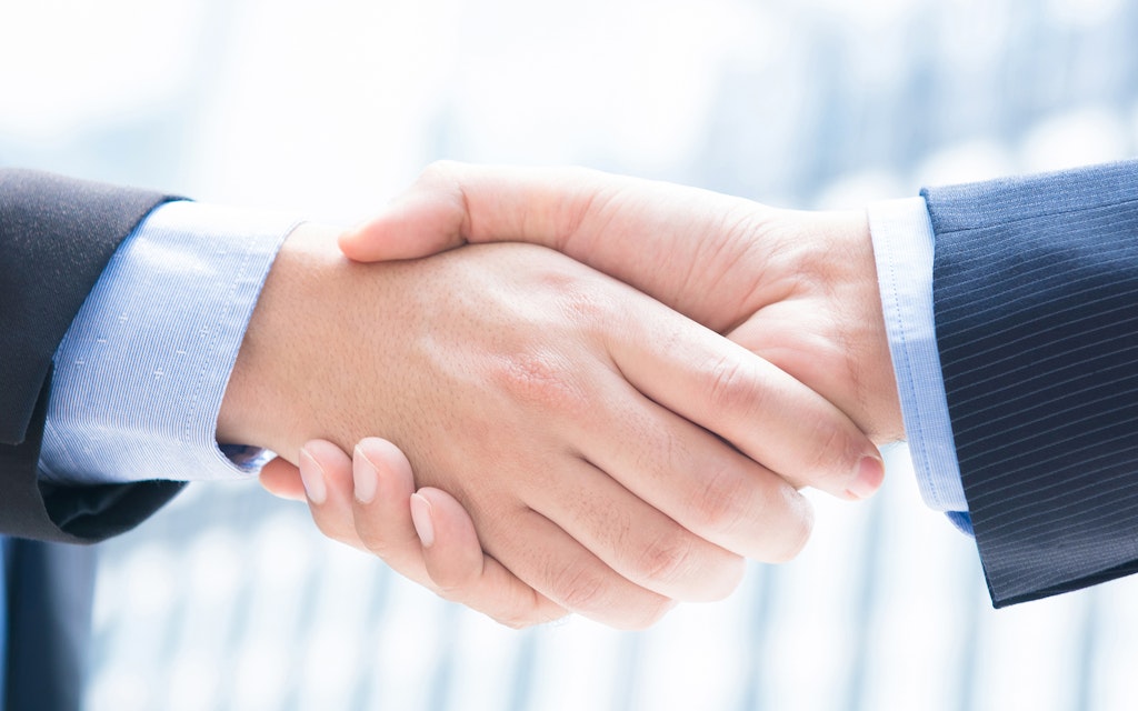 Close-up of a businessman's hands shaking hands, panorama banner