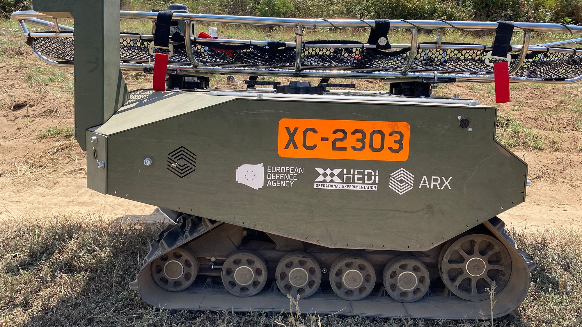Technisches Gerät im Einsatz. Die Seitenansicht zeigt Logos und Schriftzüge der Europäischen Verteidigungsagentur (EVA) und dem Hub for EU Defence Innovation (HEDI).