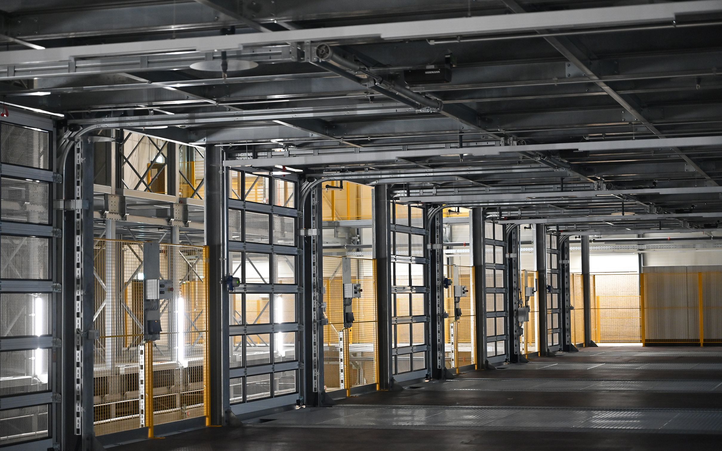 Der Neubau besteht aus einem massiven Betonkern, den eine funktionale Stahlskelettkonstruktion umgibt. 600 Container mit einem maximalen Gewicht von je 16 Tonnen kann die Armee darin künftig einlagern.