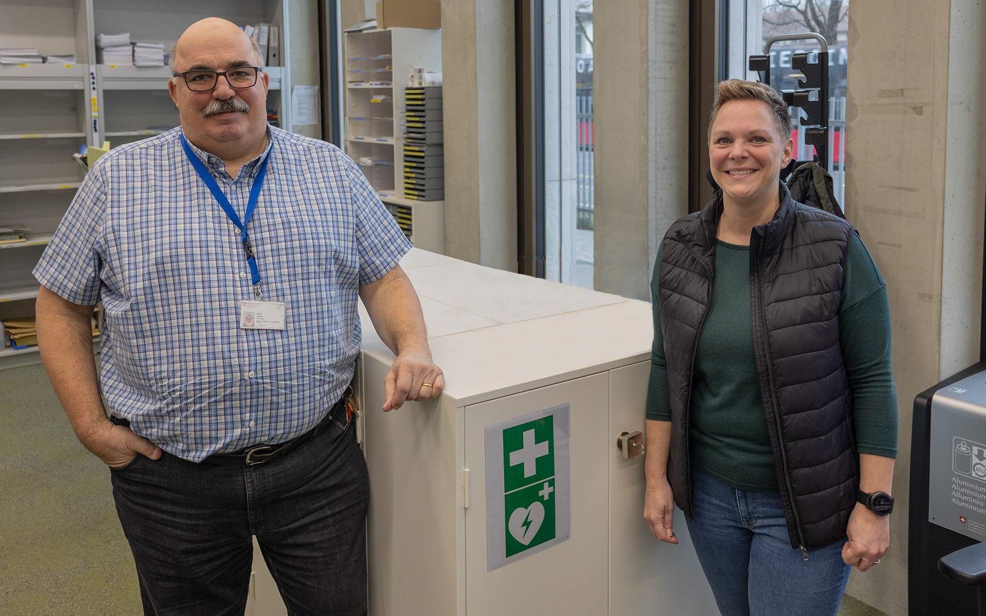 Foto von Adrian Bieri und Manuela Brülhart vor einem Sideboard in der Infrastruktur