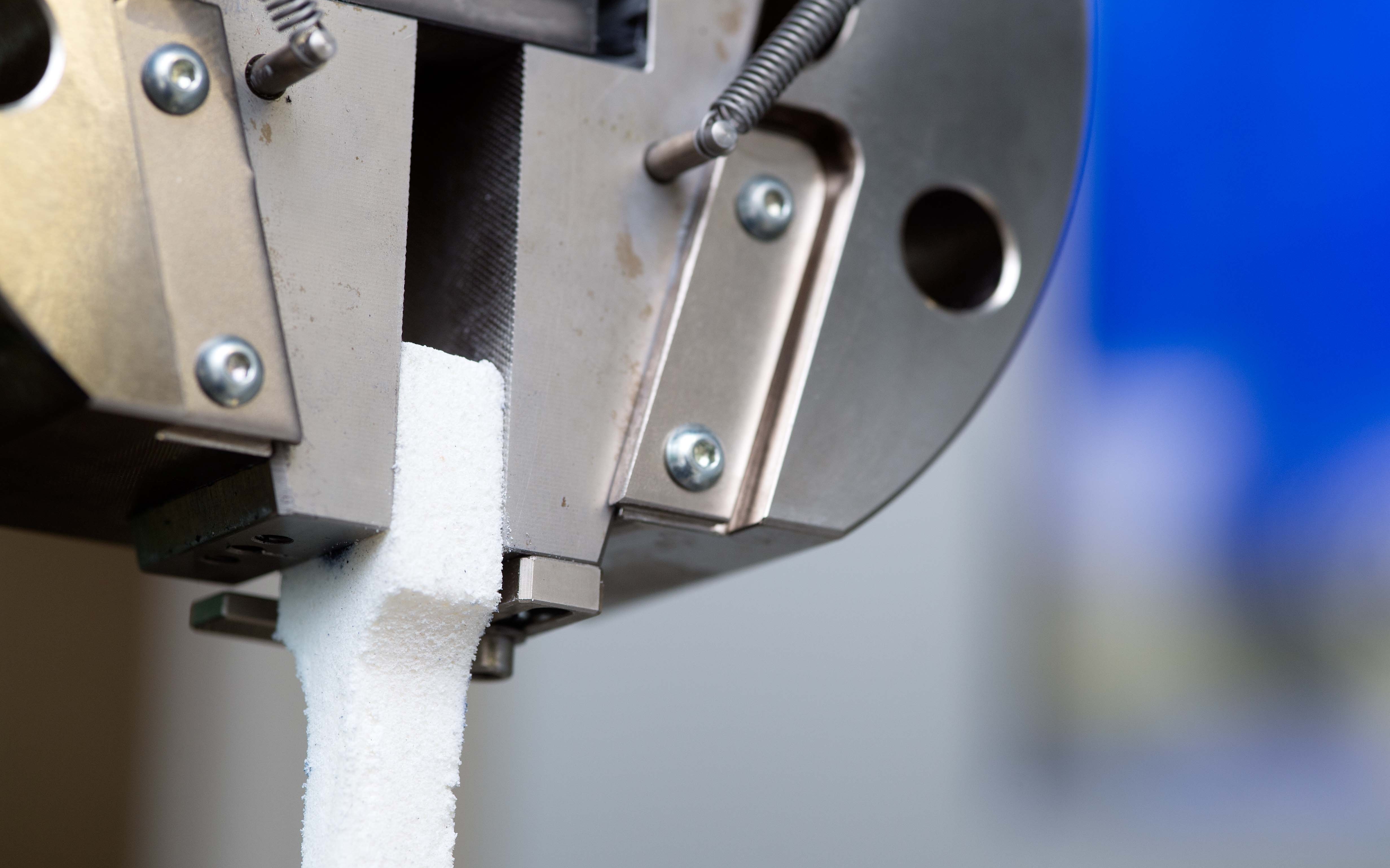 Eine Zange reisst an einem Objekt, um es auf dessen mechanischen Eigenschaften zu überprüfen