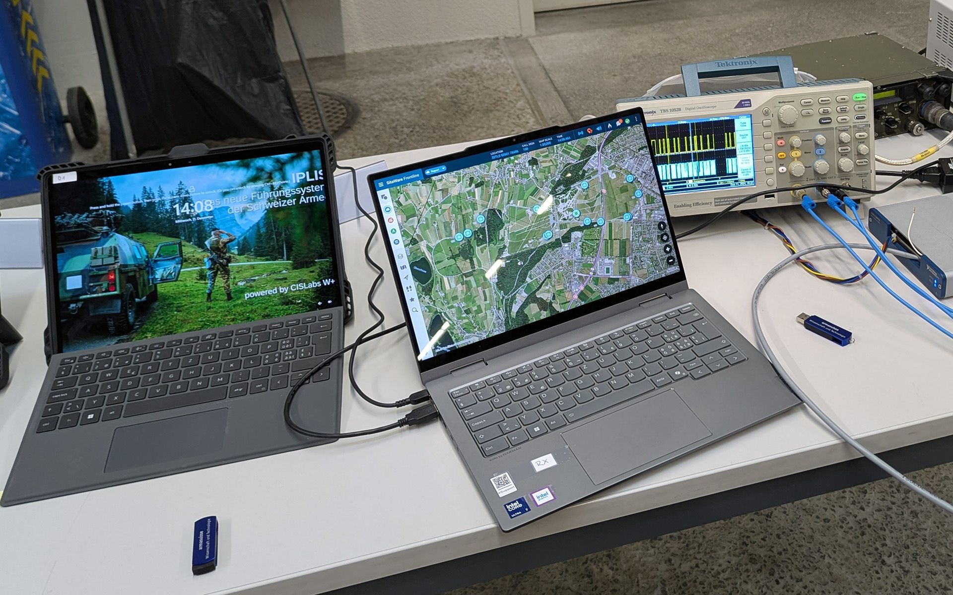 Zwei verkabelte Computer auf einem Tisch.