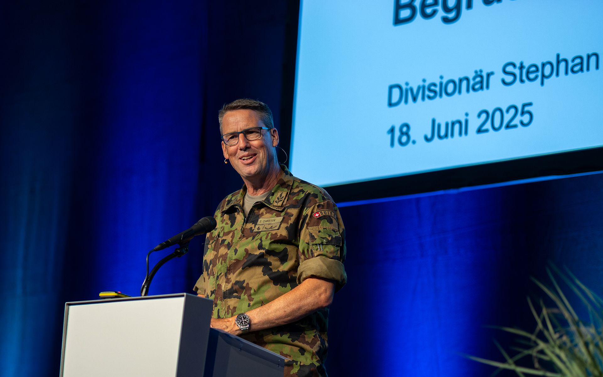 Eine Person hält ein Referat an einem Rednerpult vor einem grossen Publikum