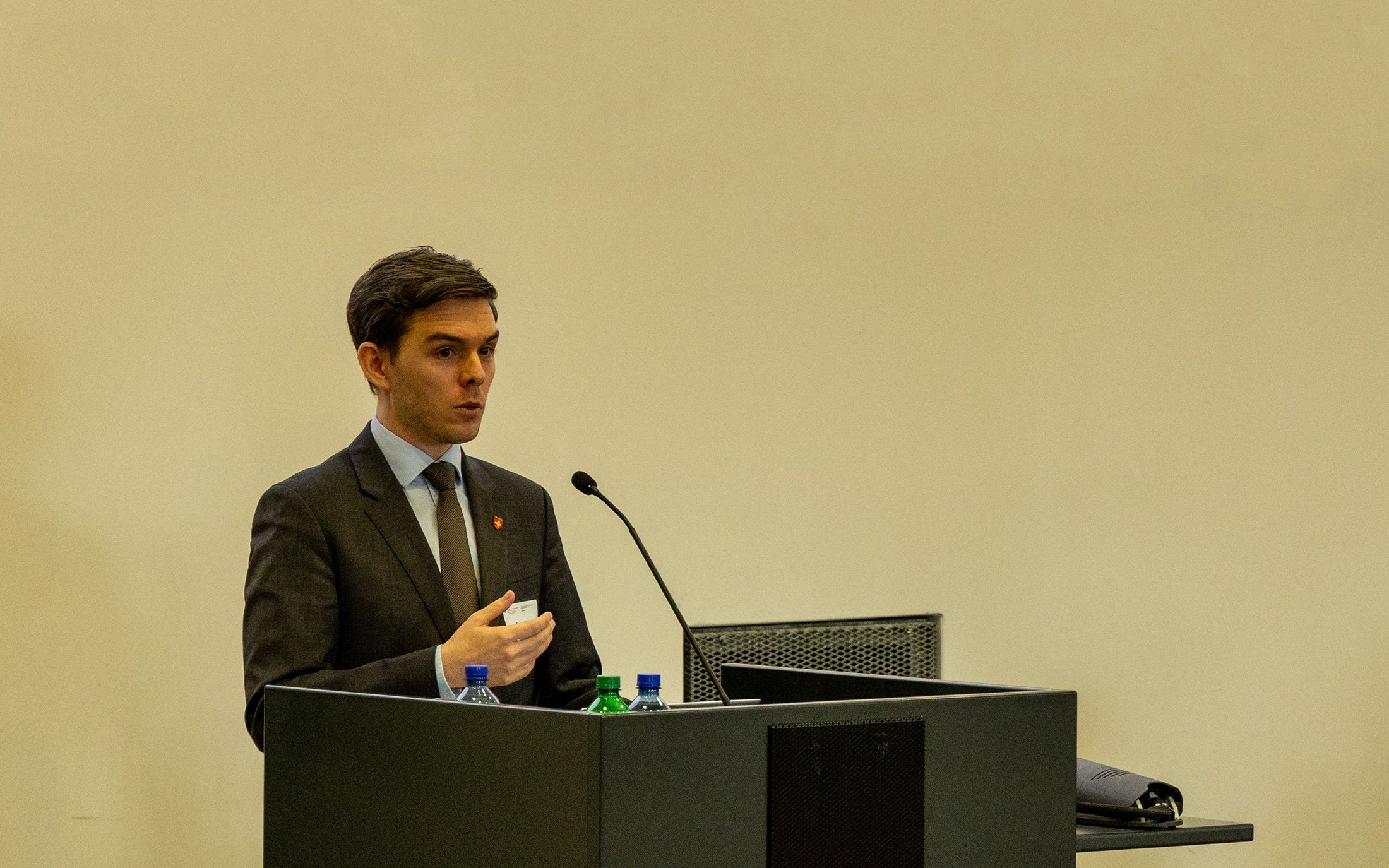 Pascal Richter, Mitarbeiter SECO steht hinter einem Rednerpult in einem Saal der Mannschaftskaserne Bern