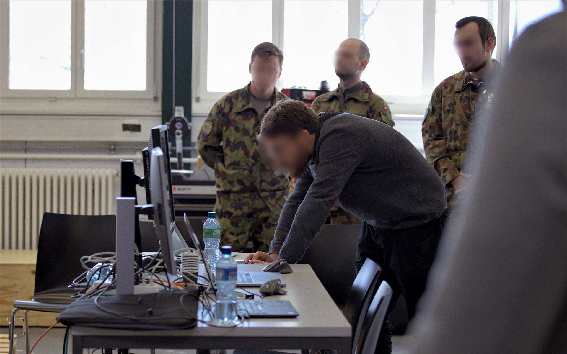 Teilnehmende des ICS Hackathons stehen vor einem Computer