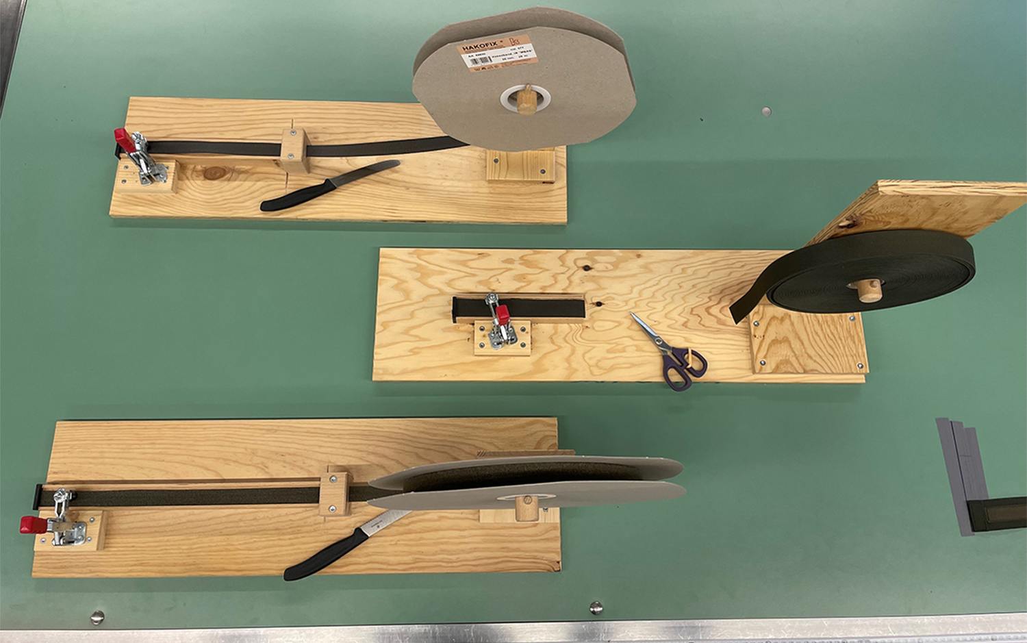 Arbeitsplätze für das Zuschneiden der Klettbänder sind mit Schablonen und Küchenmesser ausgestattet.