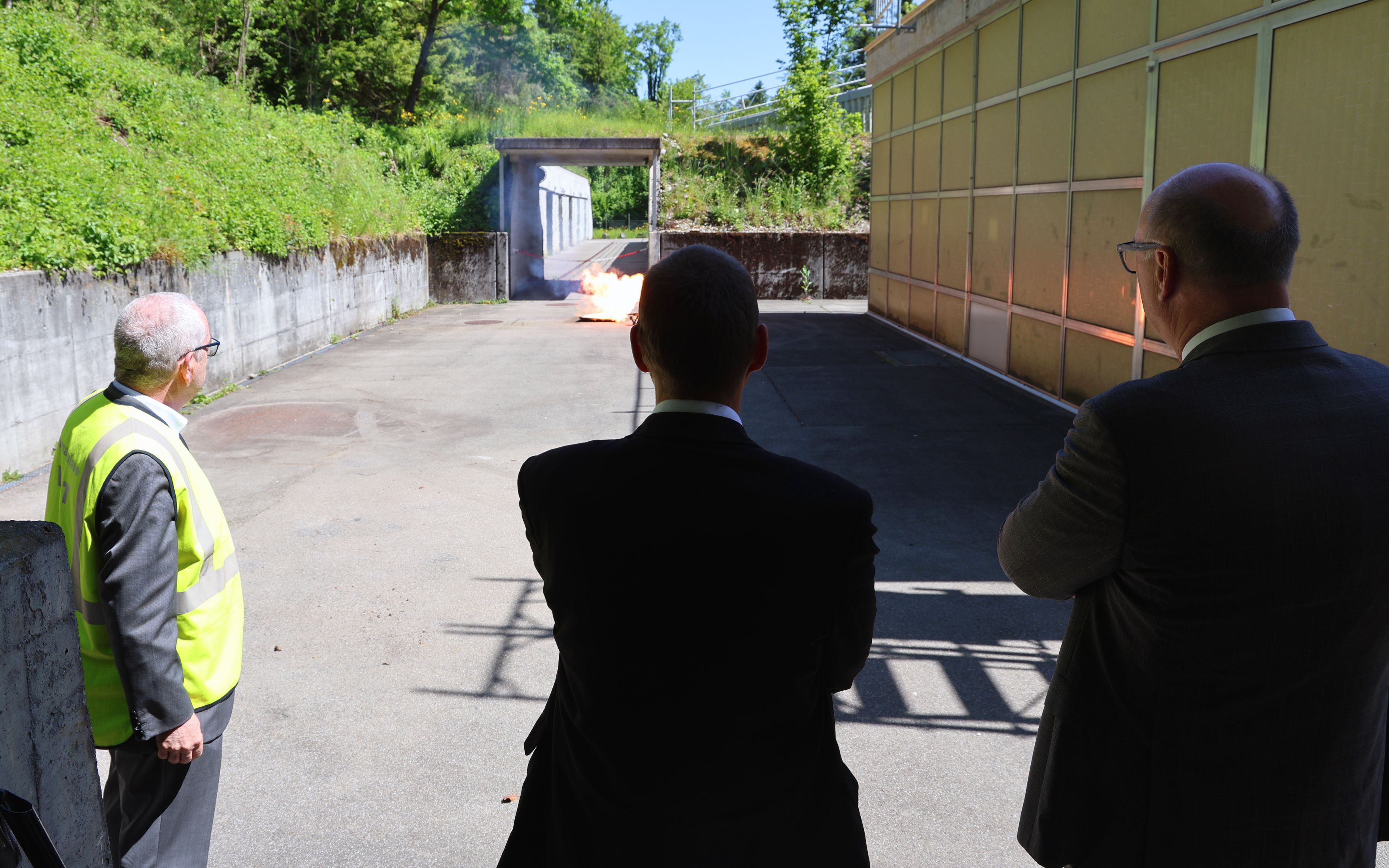 Sieben Personen stehen in einer Reihe auf einer Terrasse vor Eiger, Mönch und Jungfrau
