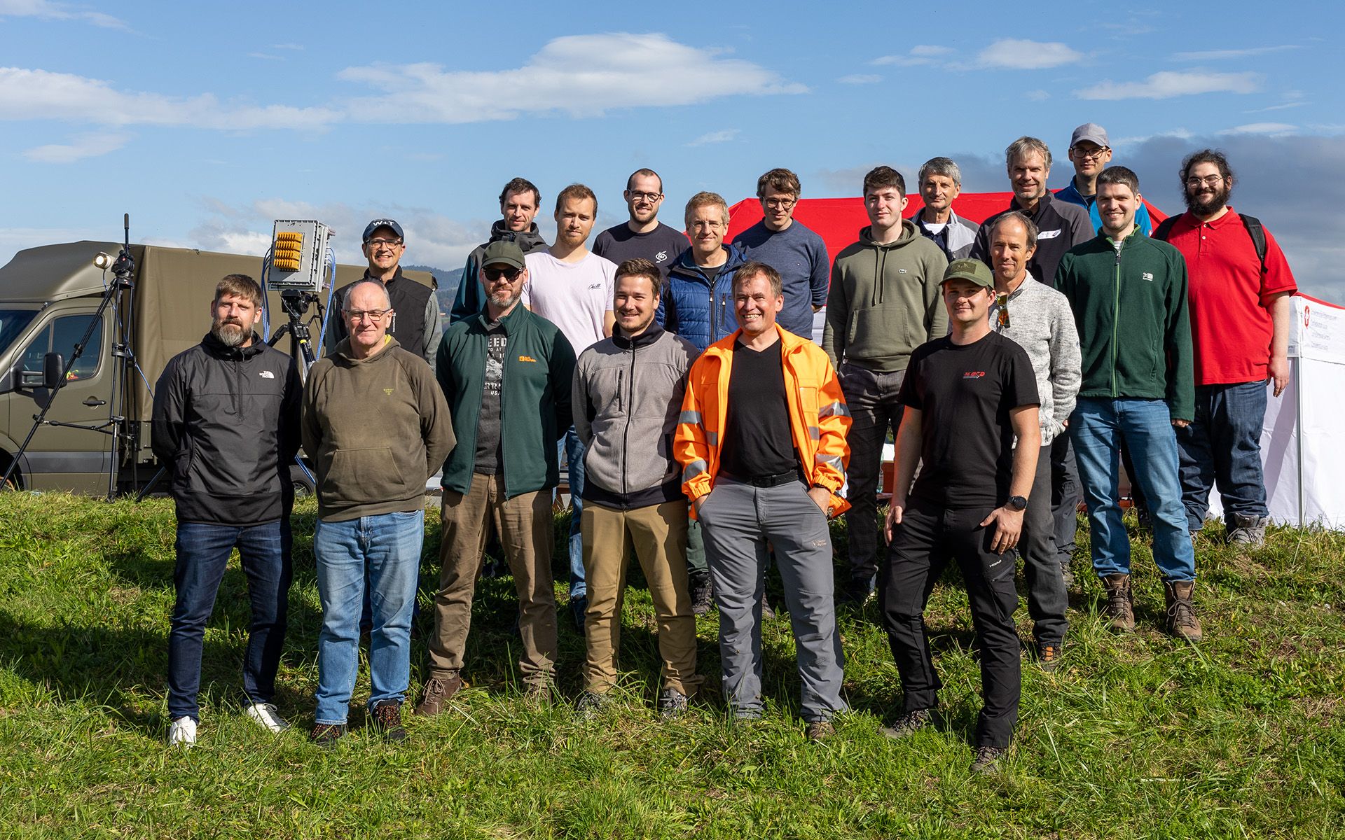 Ein Gruppenfoto bestehend aus rund 20 Personen in einem offenen Gelände
