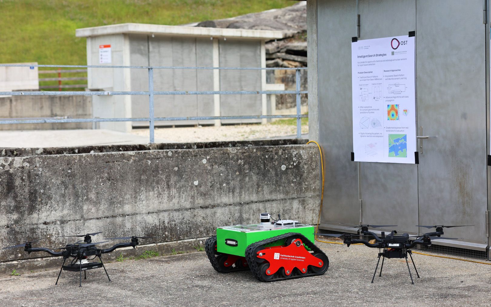 Zwei Drohnen stehen neben einem grünen Roboter.