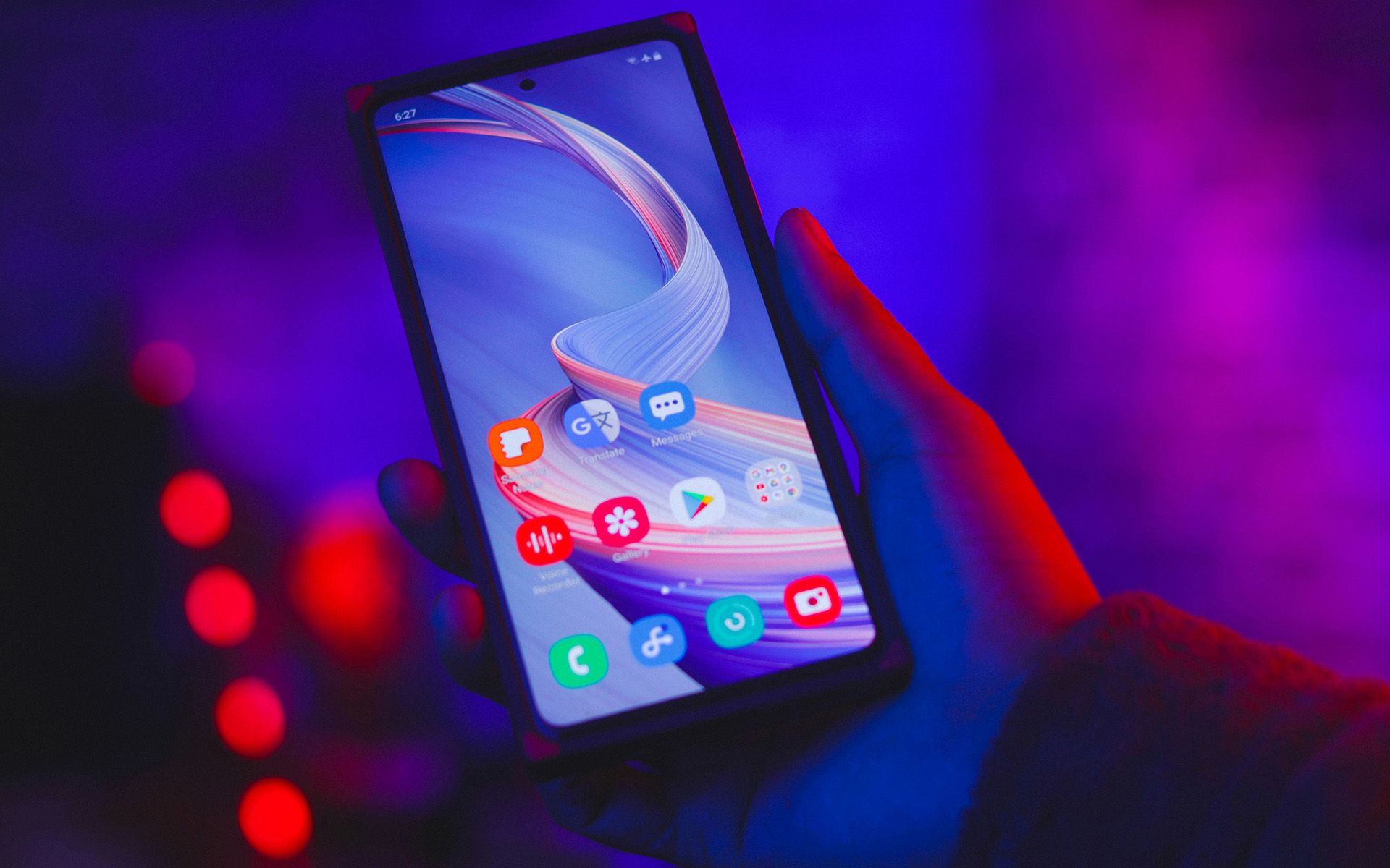 Mobiltelefon in der Hand mit blau-violettem Hintergrund