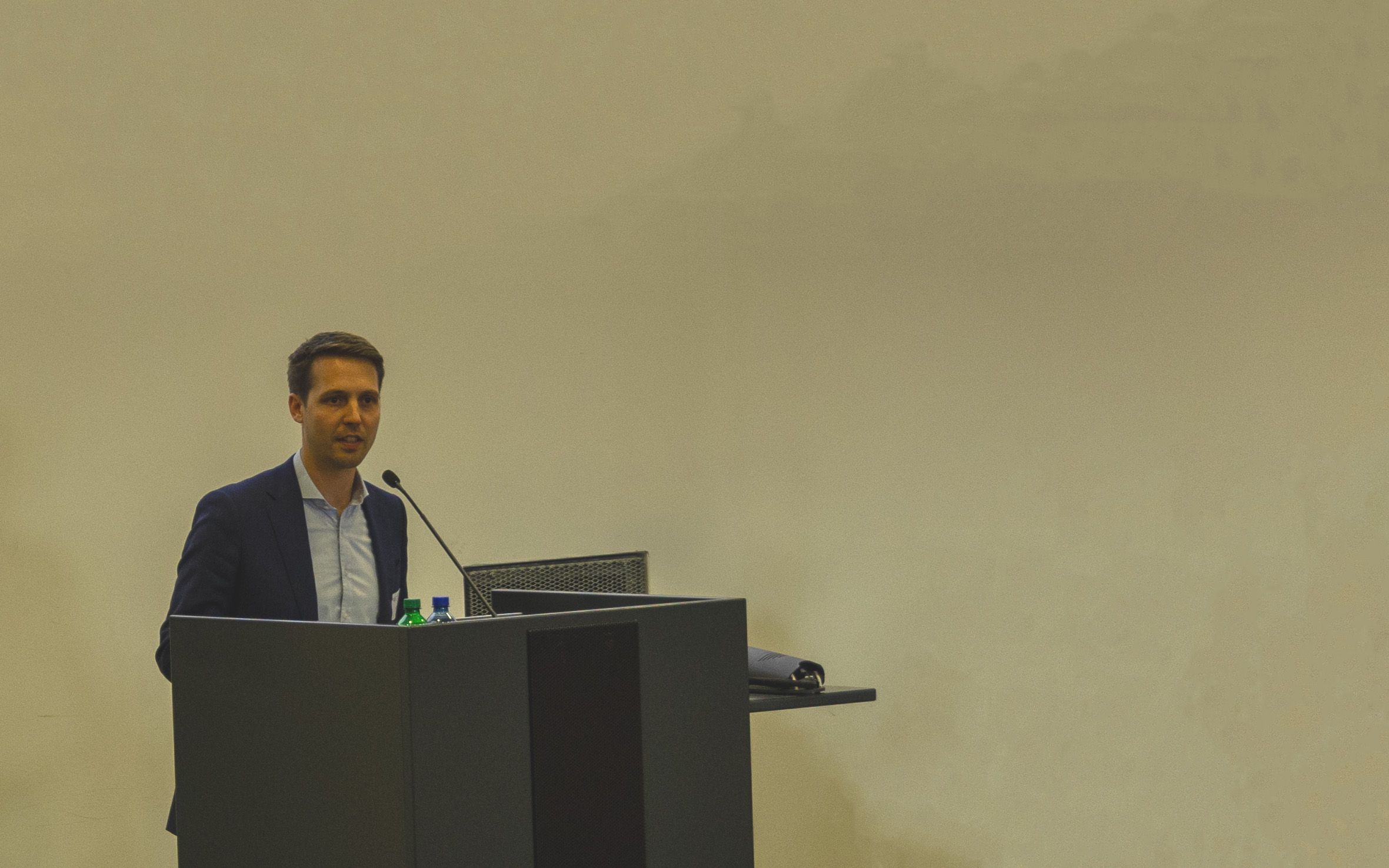 Kai Holtmann, Managing Director Taskforce Drohne steht hinter einem Rednerpult in einem Saal der Mannschaftskaserne Bern