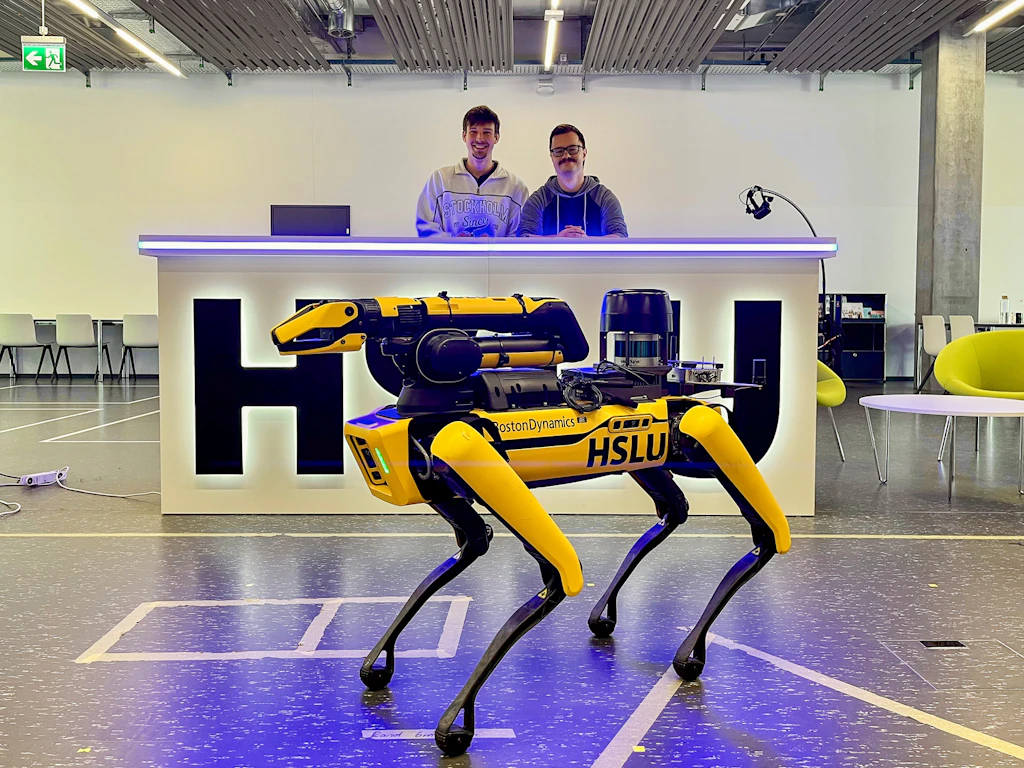 Group photo of Team BeBot with a four-legged walking robot