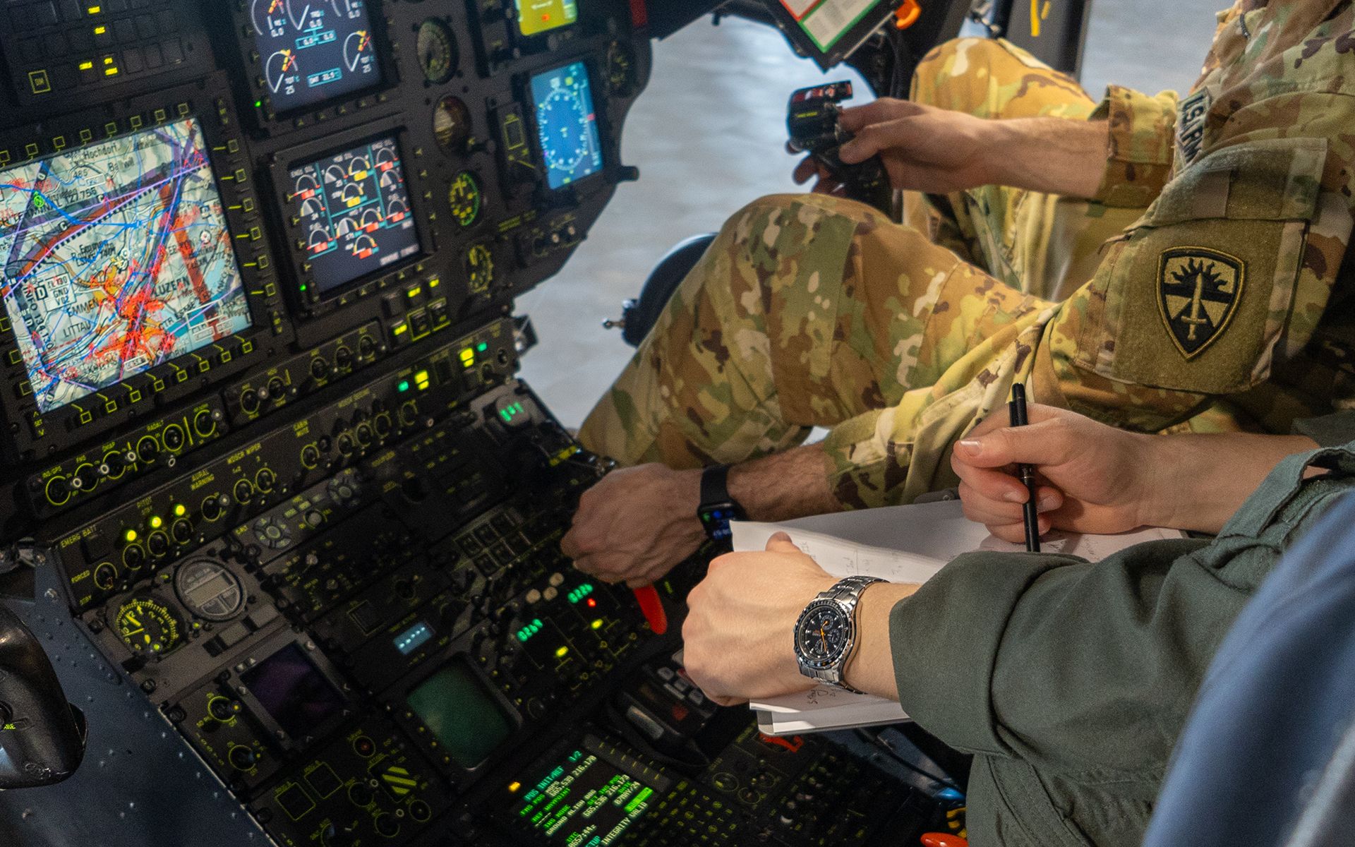 Two hands can be seen above a helicopter control panel.