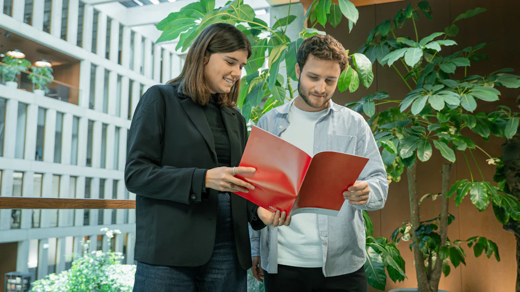 A man and a woman are looking at a booklet.