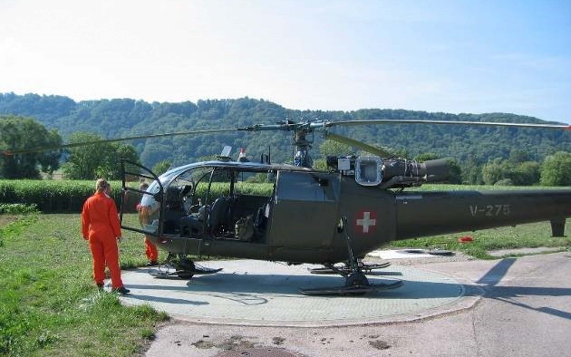 A helicopter stands on an open-air airfield.