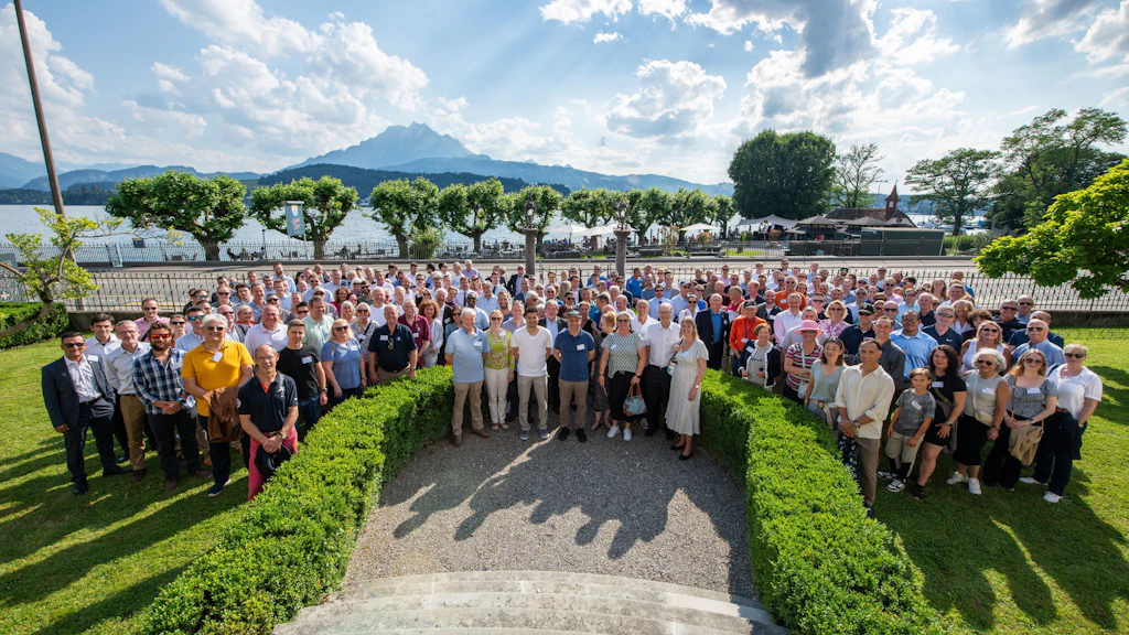 A group of people is standing together in several rows