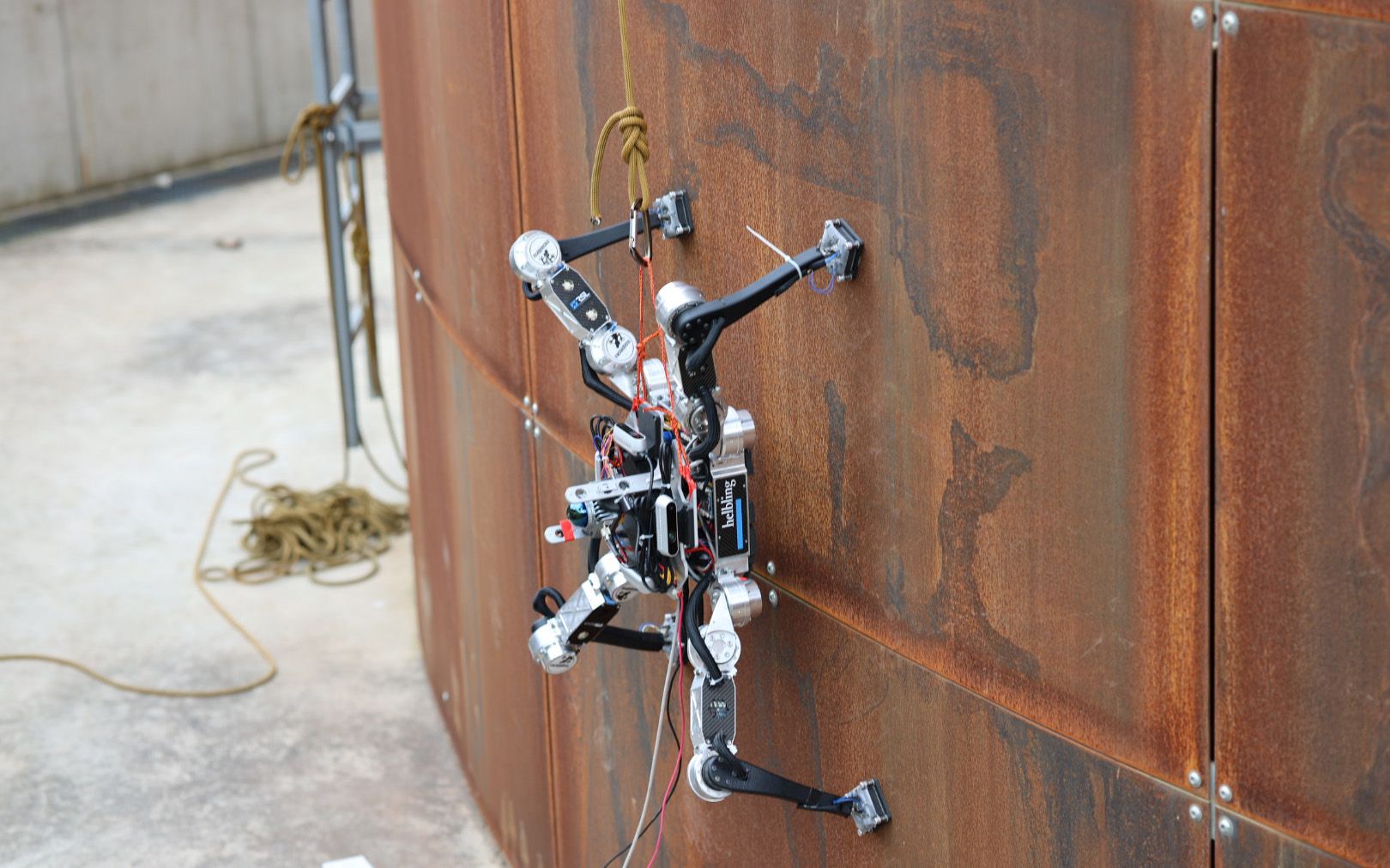 A robot is located on a metal wall. 