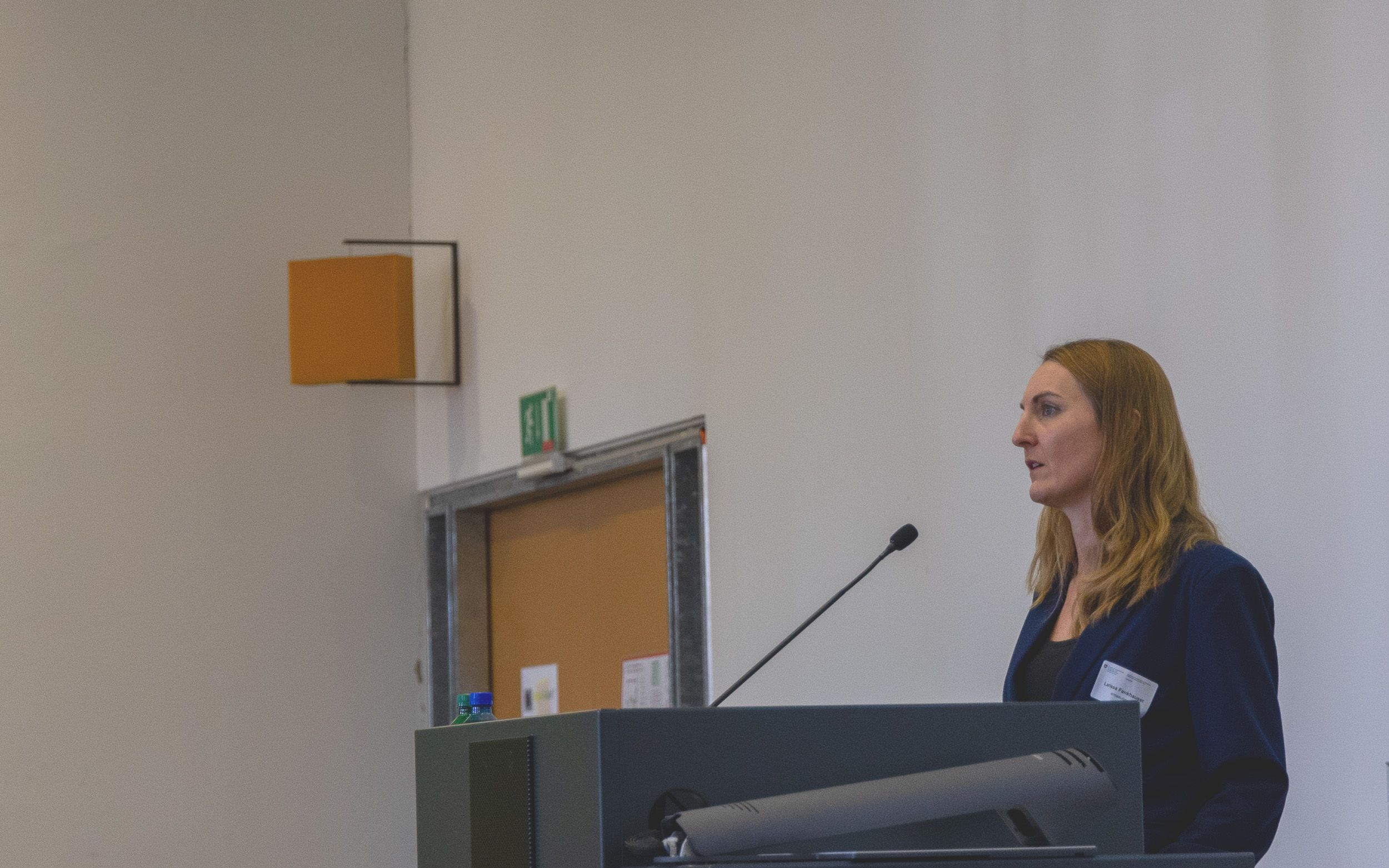 Larissa Fankhauser, legal expert from armasuisse Procurement stands behind a speaker’s podium in a room of the staff barracks in Bern