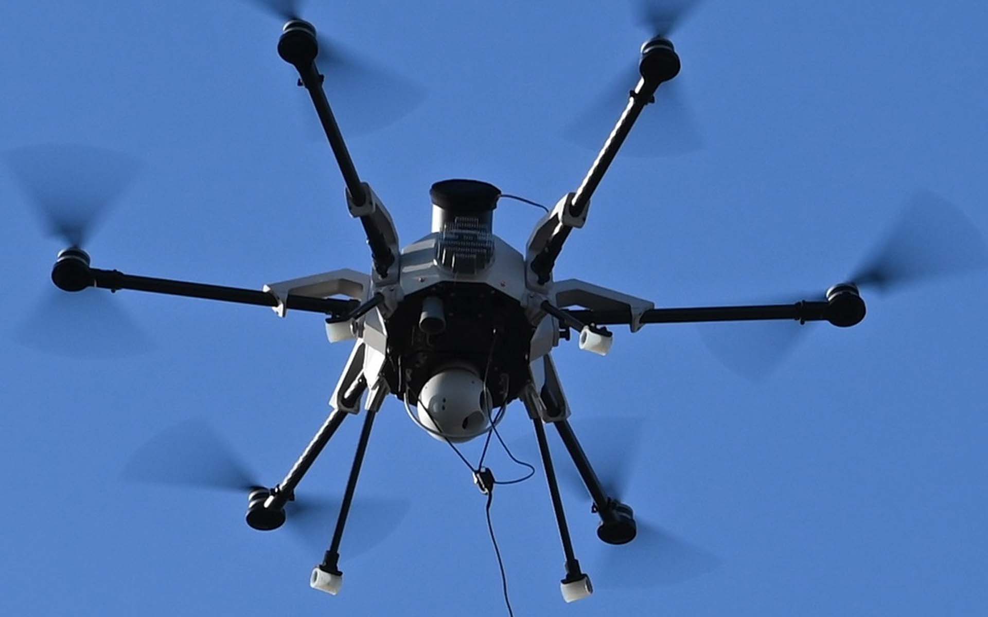 Photo of a large drone suspended from a rope in the air
