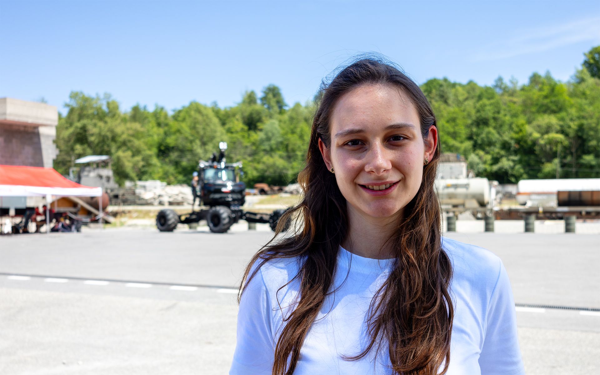 Portrait picture of Patricia Solano, project manager ARCHE. A research demonstrator from a participating research team of ARCHE can be seen in the background.