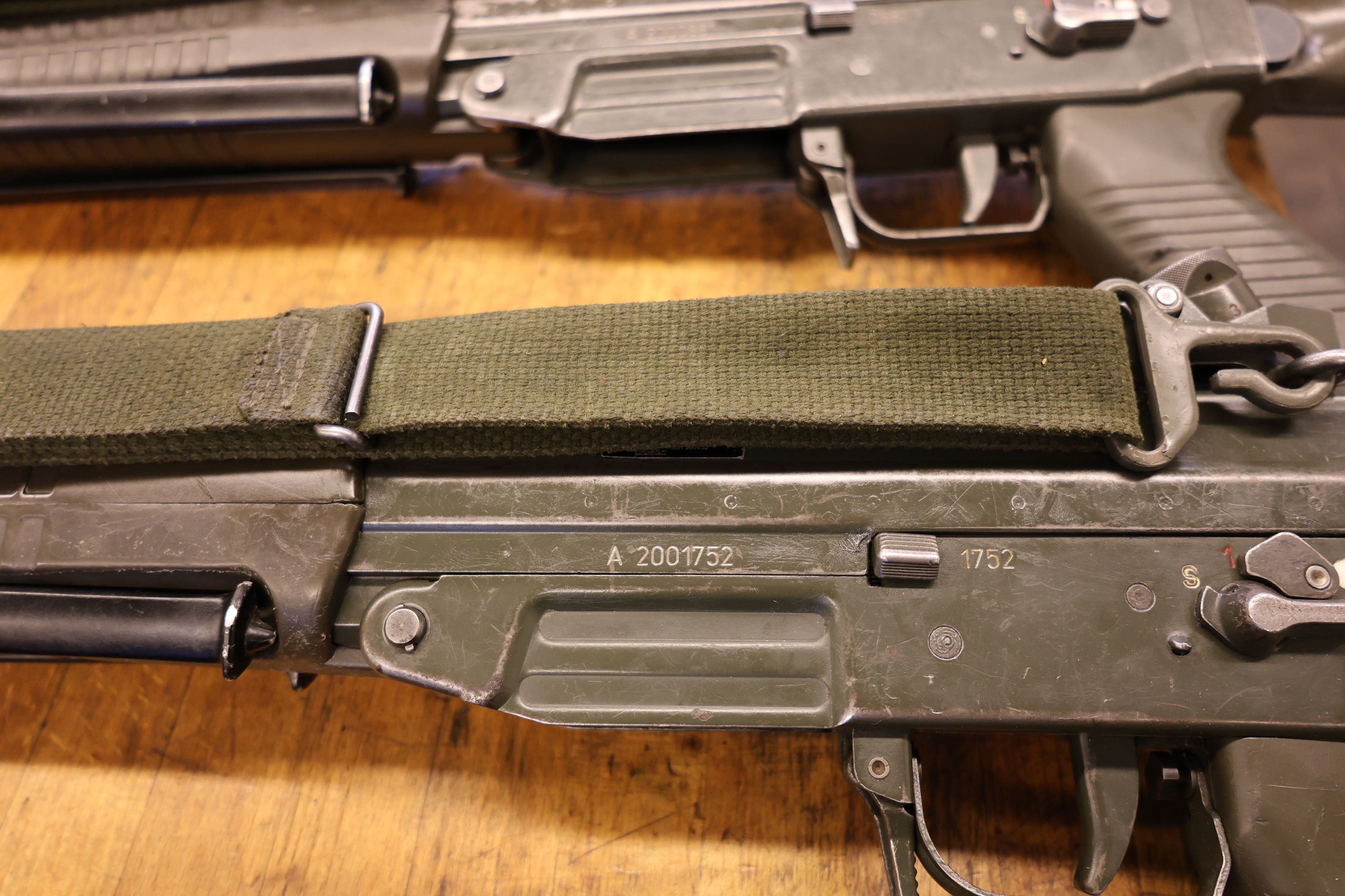 We can see the middle part of a rifle and the stamped weapon serial number.