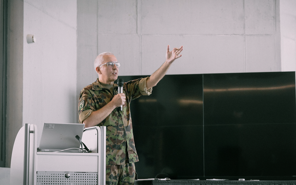 A man in military uniform stands in a room.
