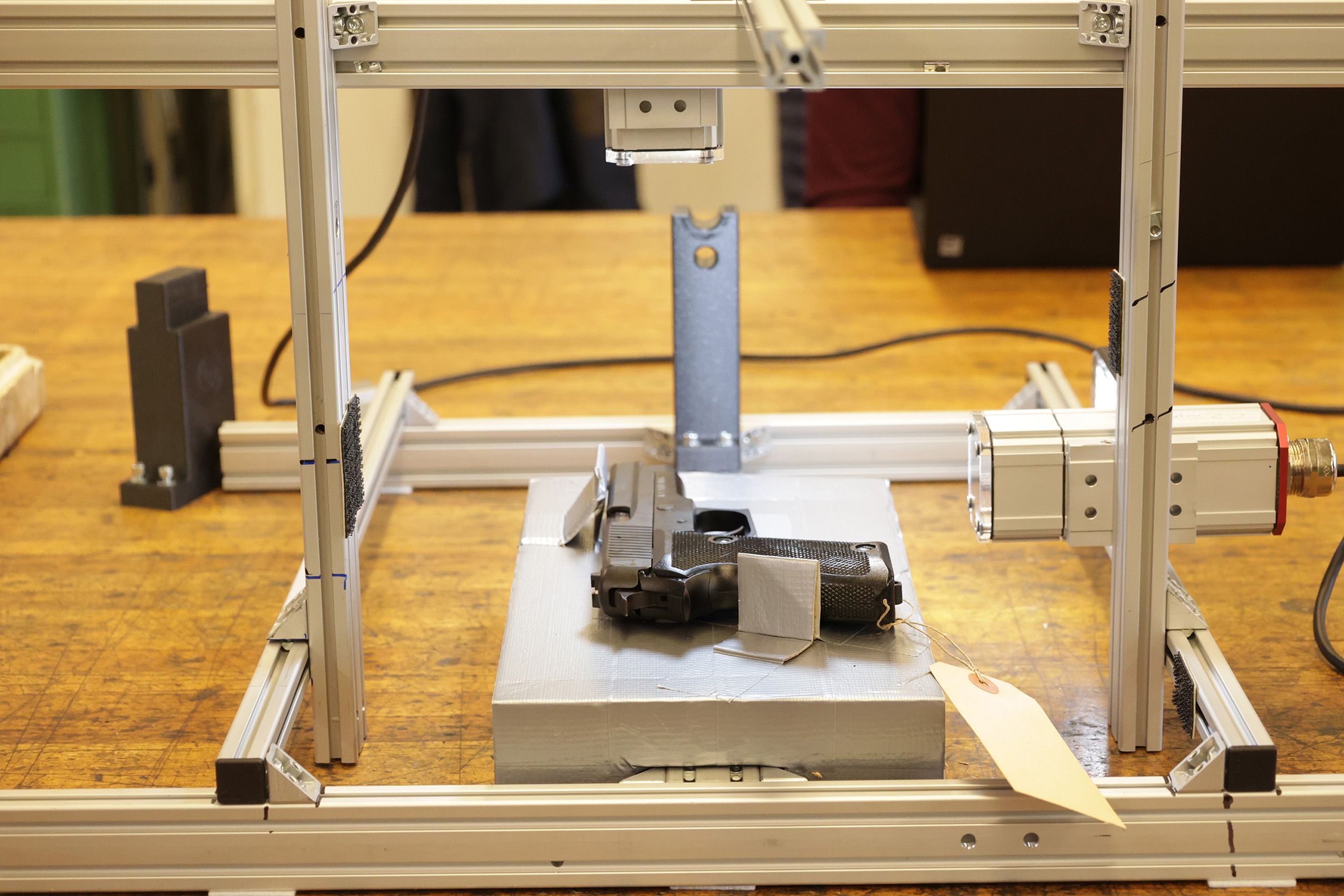 In the centre, we see the system for automatic scanning of weapon serial numbers on a table.