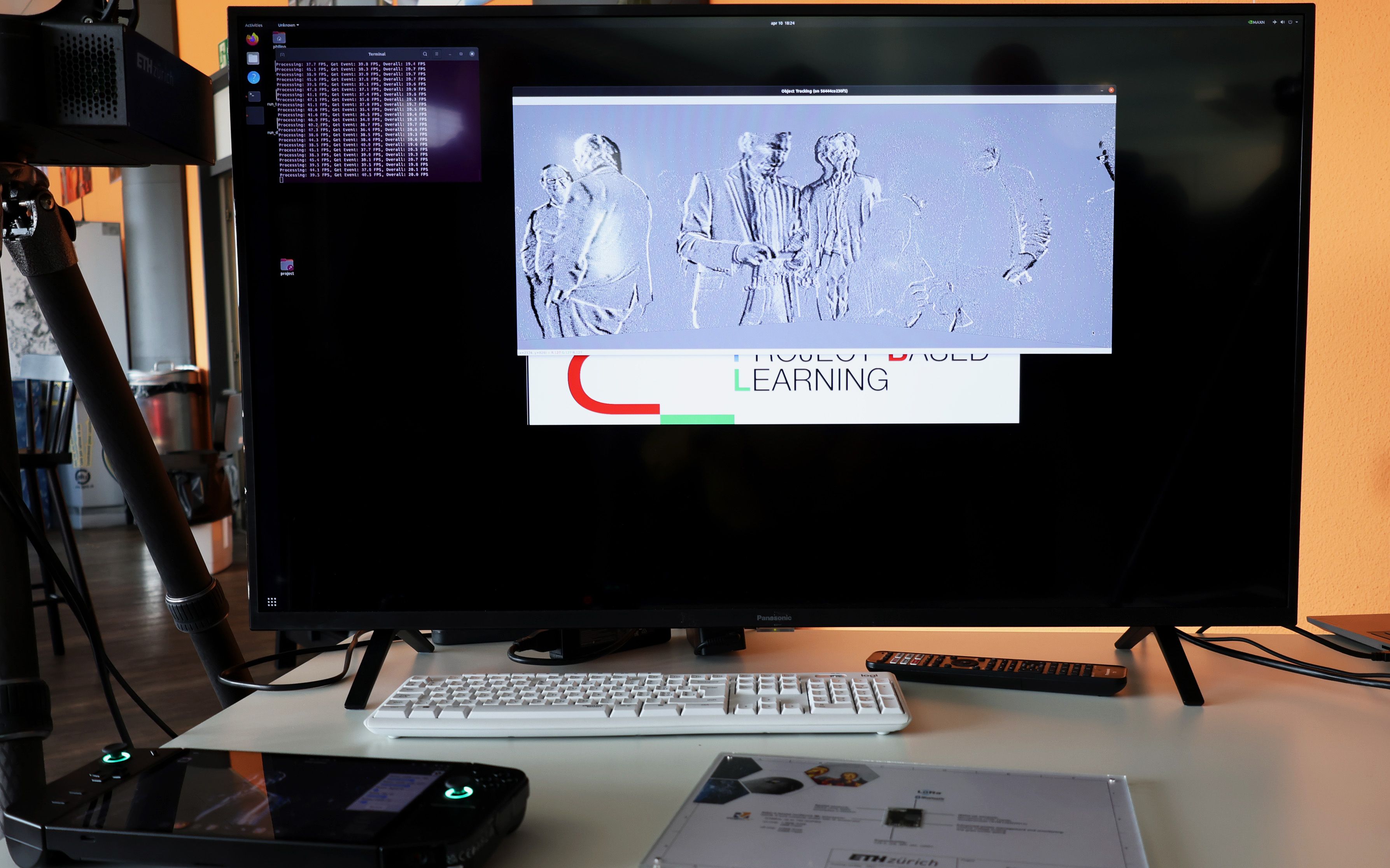 A screen, a keyboard and an operating board are on a table. 