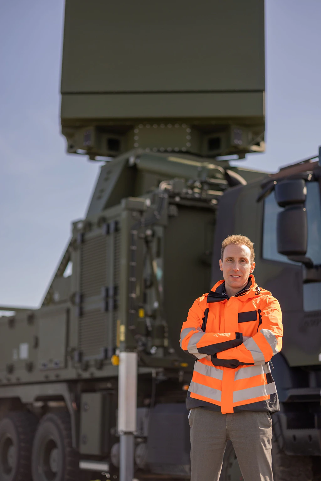 An expert from armasuisse W+T stands in front of a ground-based radar system