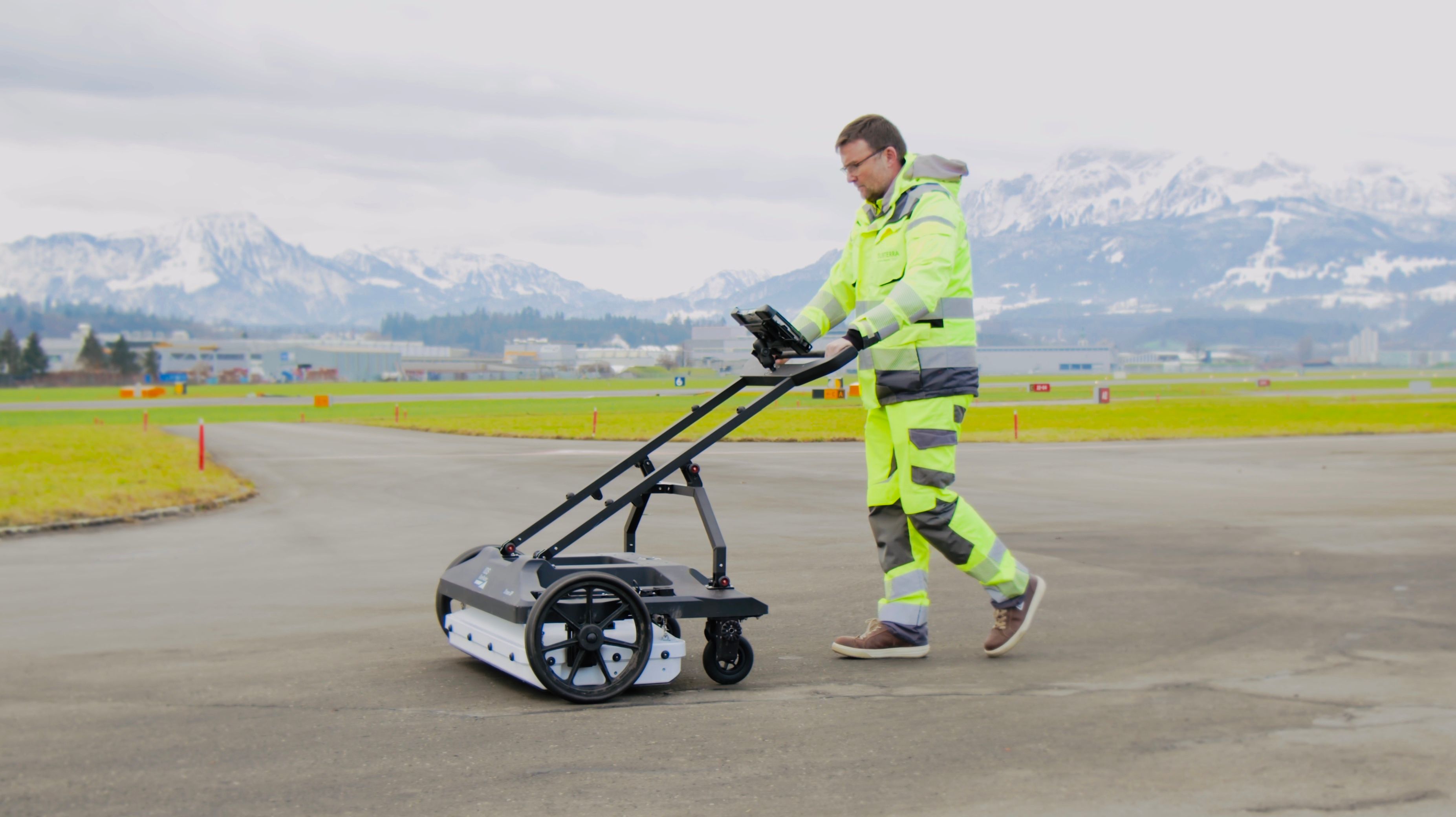 Un collaborateur pousse un radar de sol pour la prise de vue du sol sur l’aérodrome militaire d’Emmen