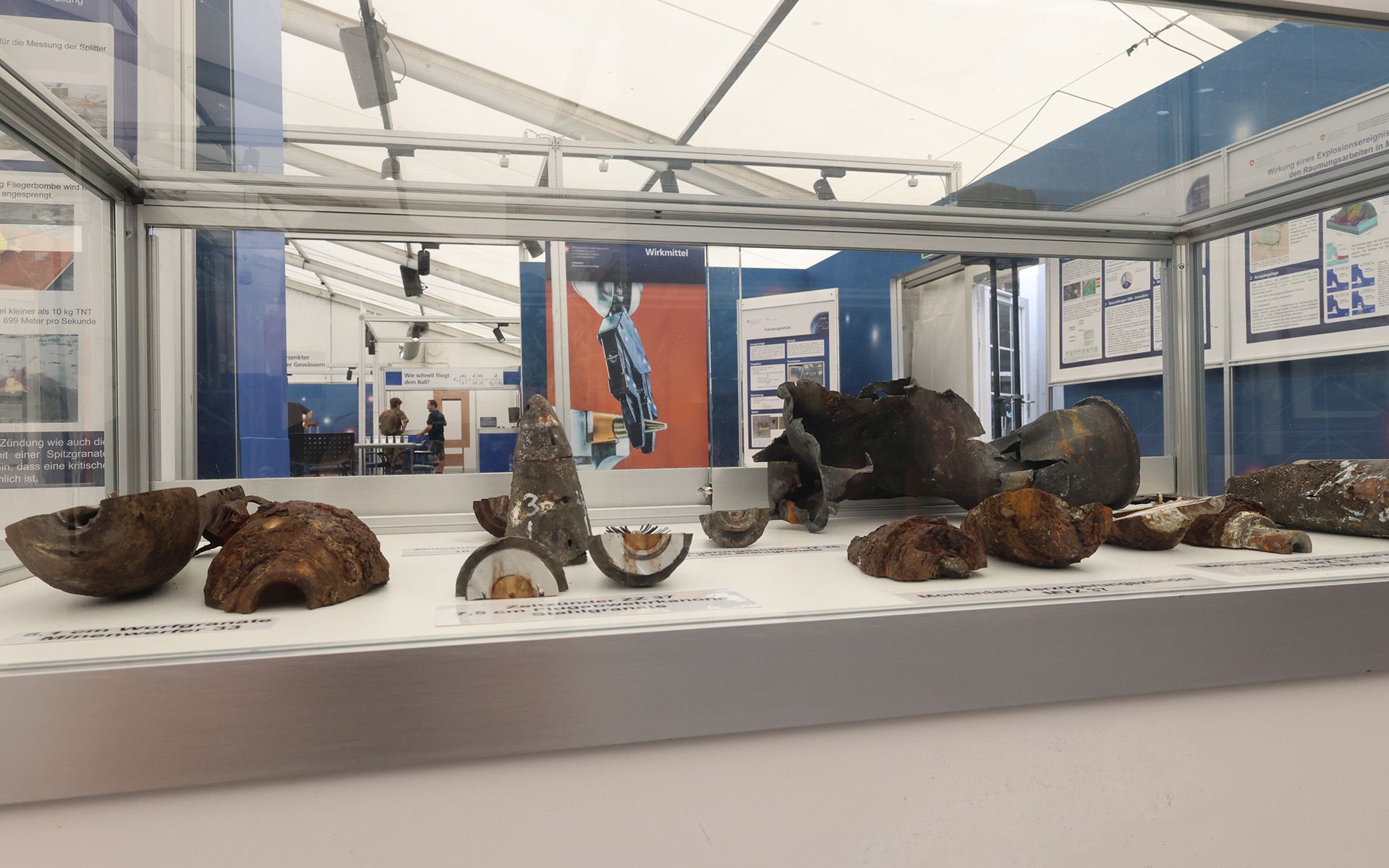 Les visiteuses et visiteurs voient dans une vitrine des résidus de munitions de Mitholz.