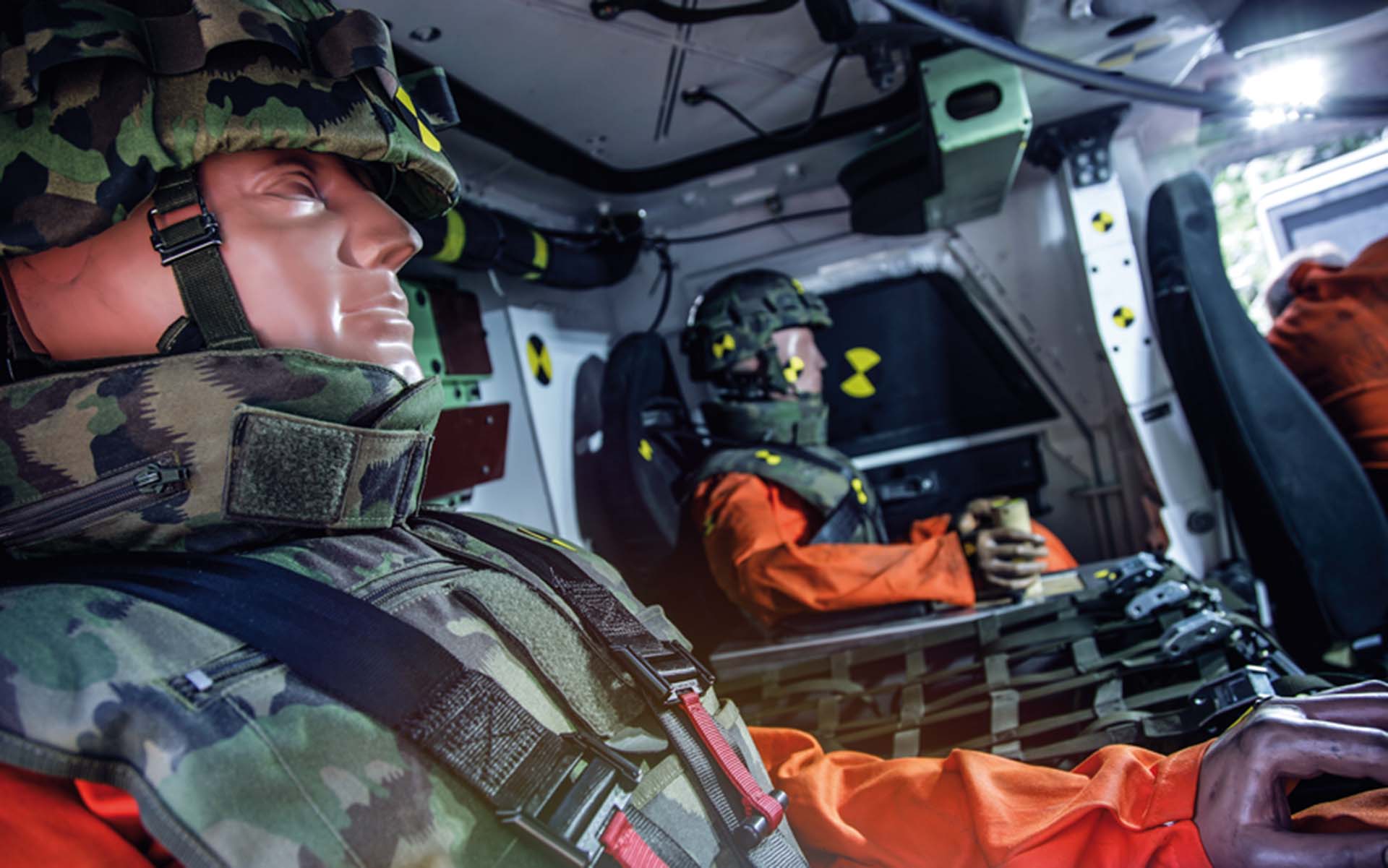 Les mannequins sont assis dans un véhicule blindé avec un équipement de protection.