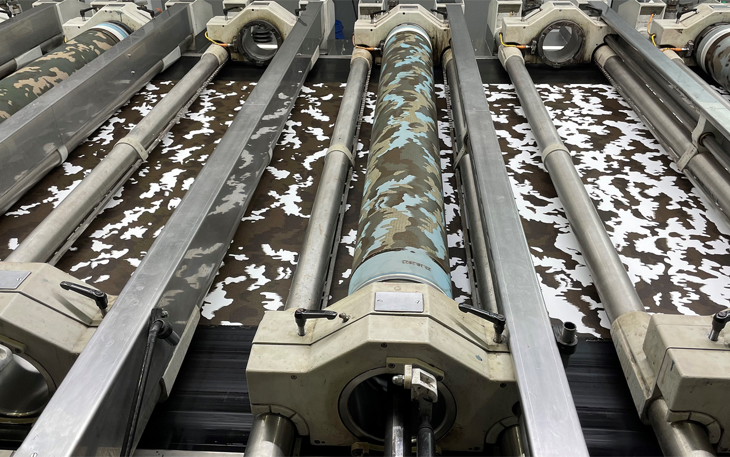 Le motif de camouflage est imprimé sur le tissu à l'aide d'un système d'impression rotatif.