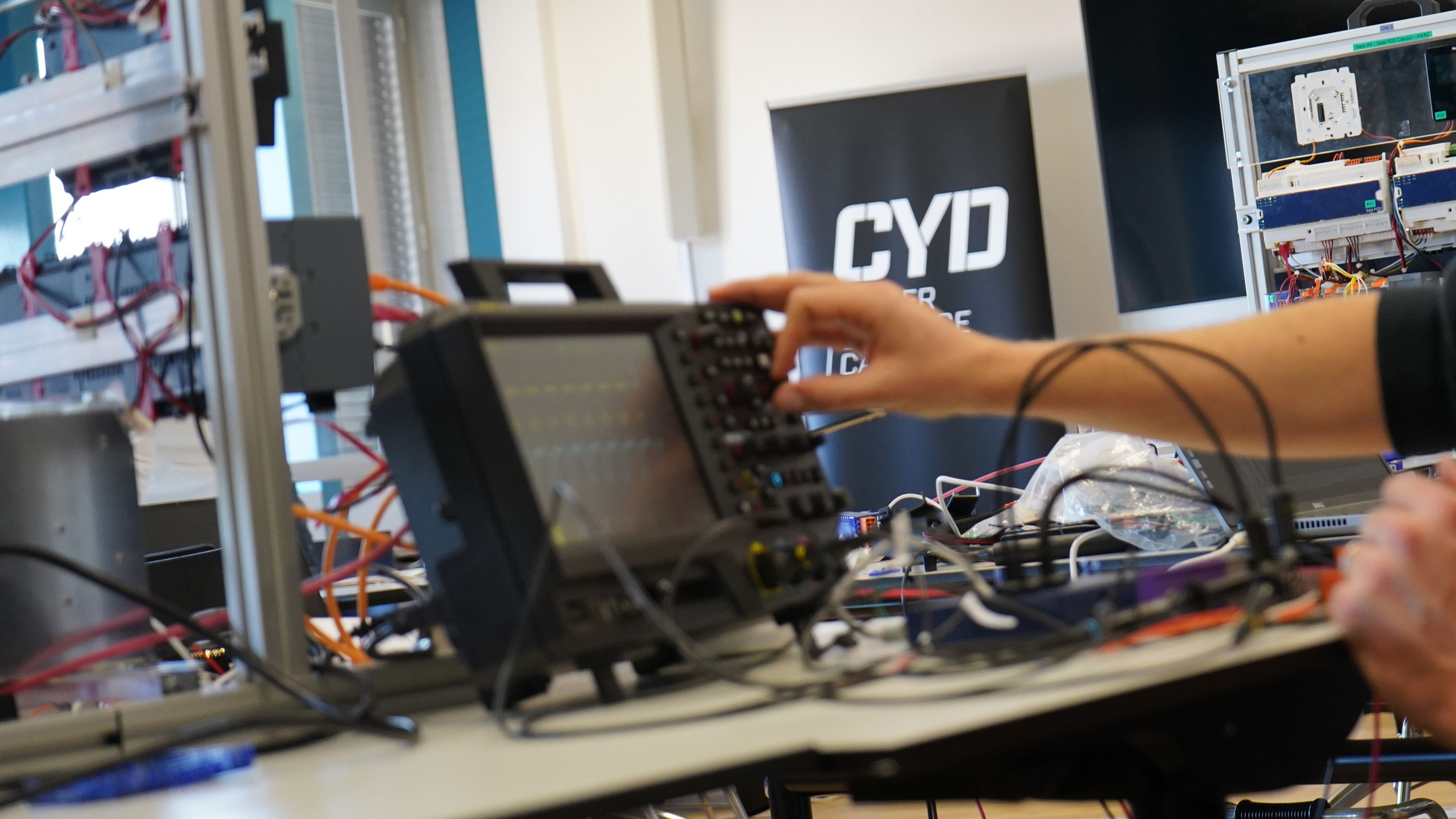 Un homme utilise un oscilloscope pour analyser les signaux sur le circuit imprimé d’un contrôleur