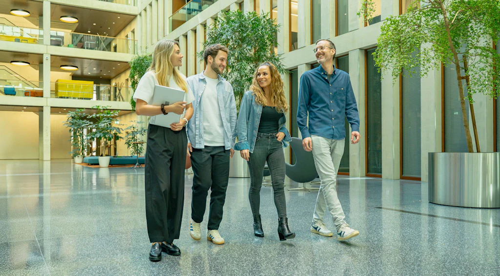 Quatre collègues traversent l’atrium.