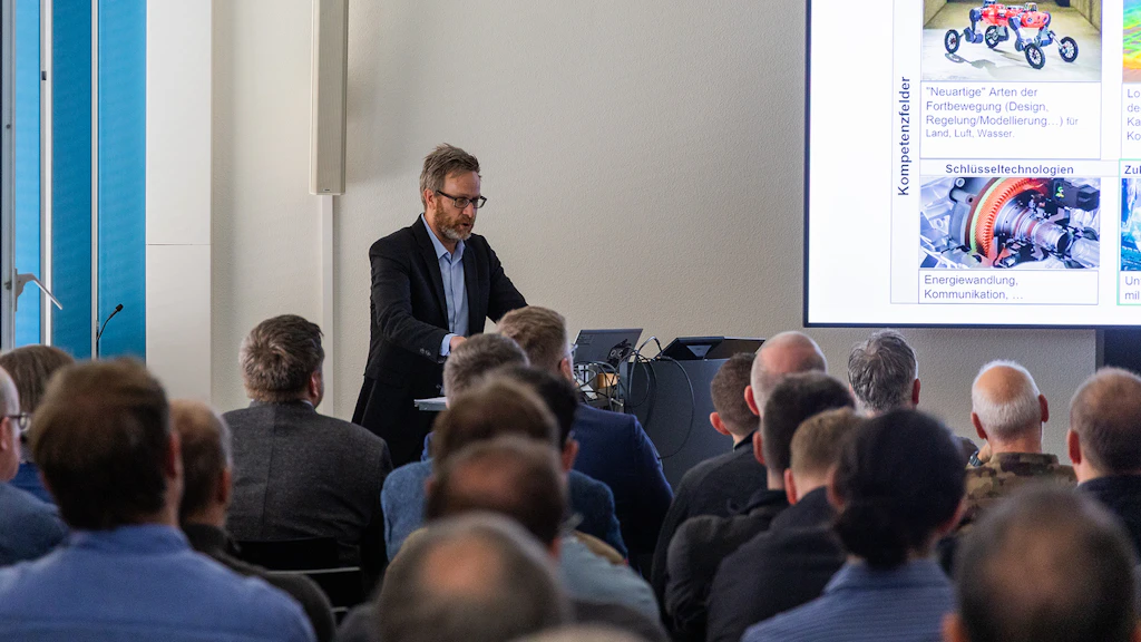 Il dott. Markus Höpflinger presenta al pubblico il programma di ricerca «Sistemi senza pilota / robotica»