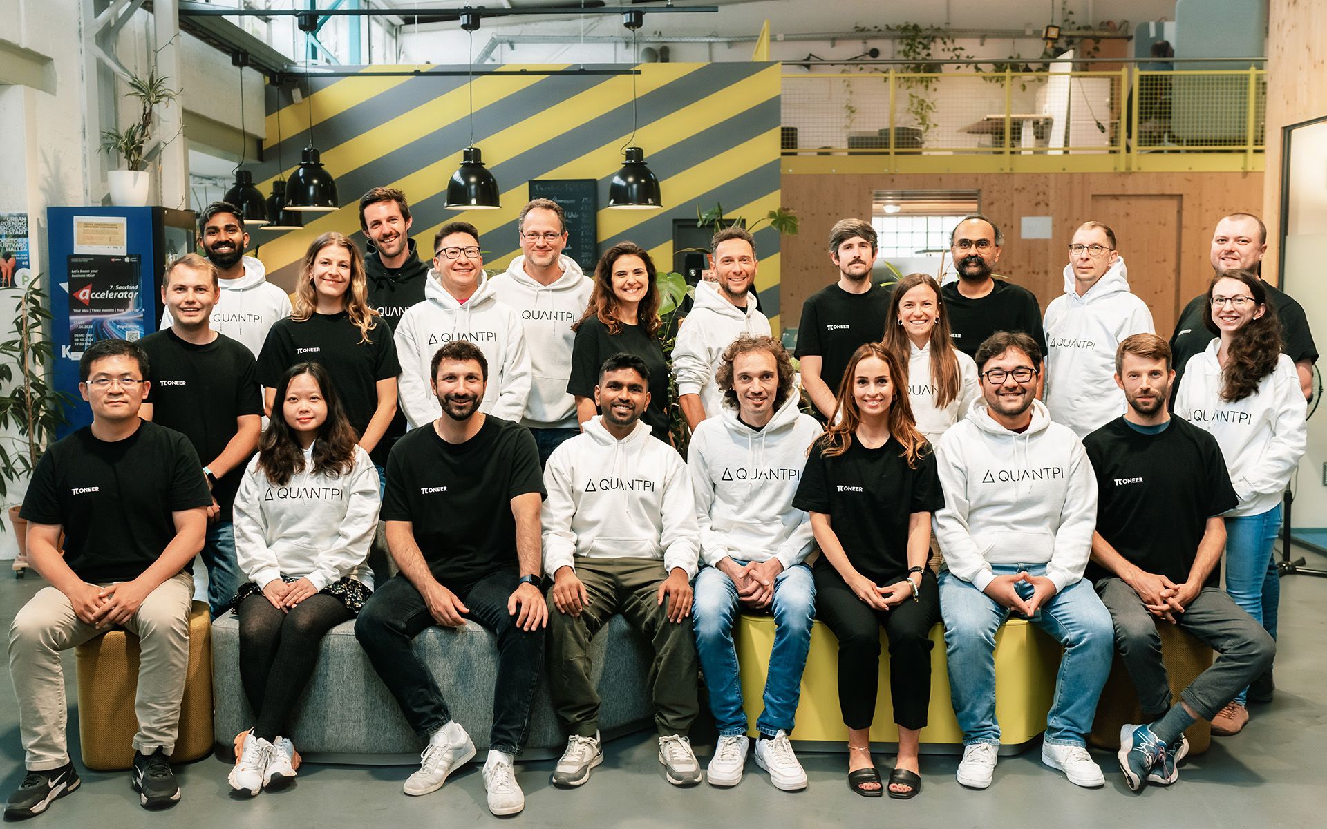 Il team di QuantPi con una fila di persone sedute e una fila di persone in piedi che guardano davanti a sé