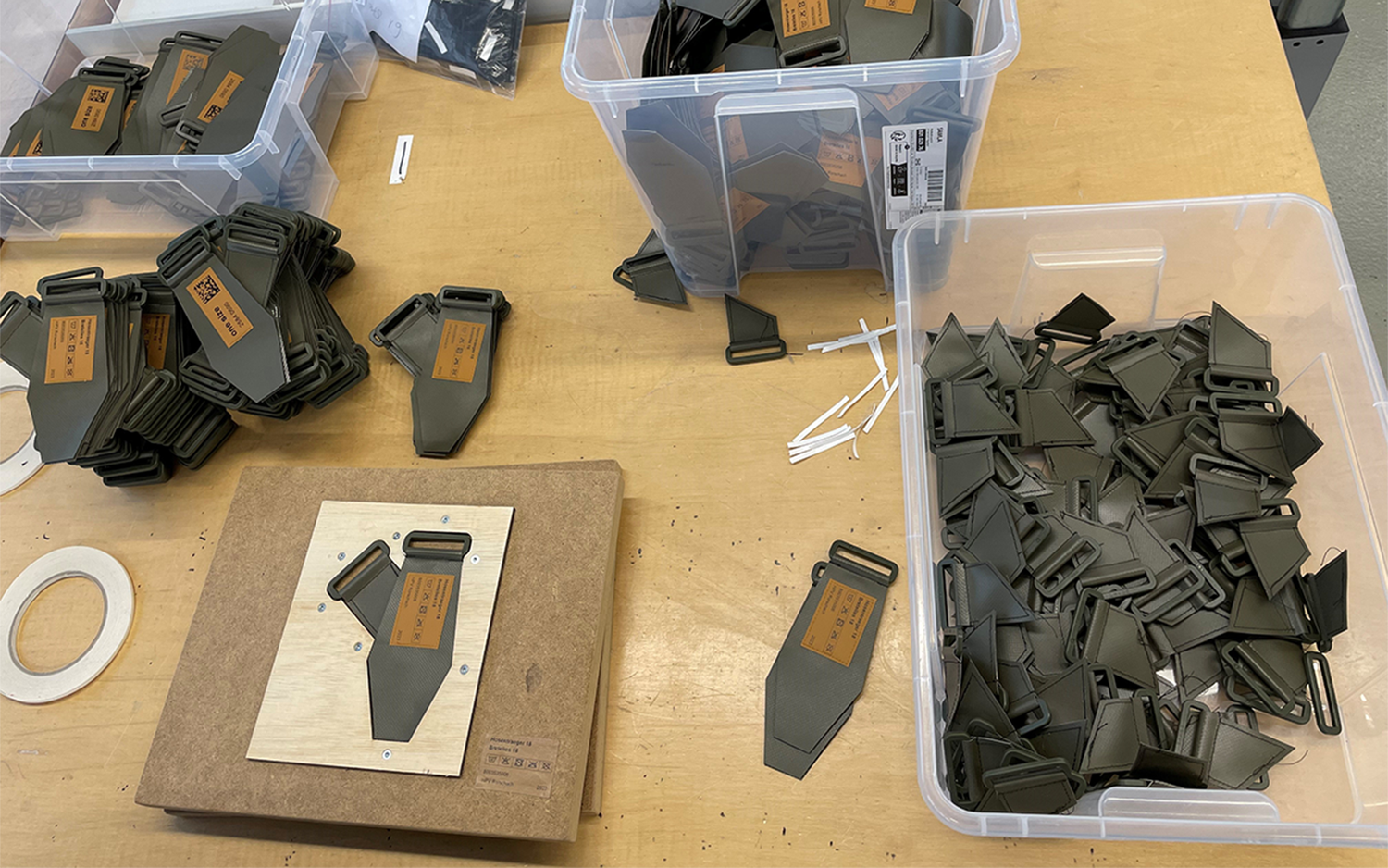 Una postazione di lavoro mostra parti di bretelle che possono essere cucite correttamente con l'aiuto di una dima.