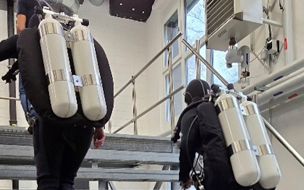 I due studenti si esercitano insieme nell'uso delle bombole subacquee per imparare a maneggiare l'attrezzatura in modo sicuro.