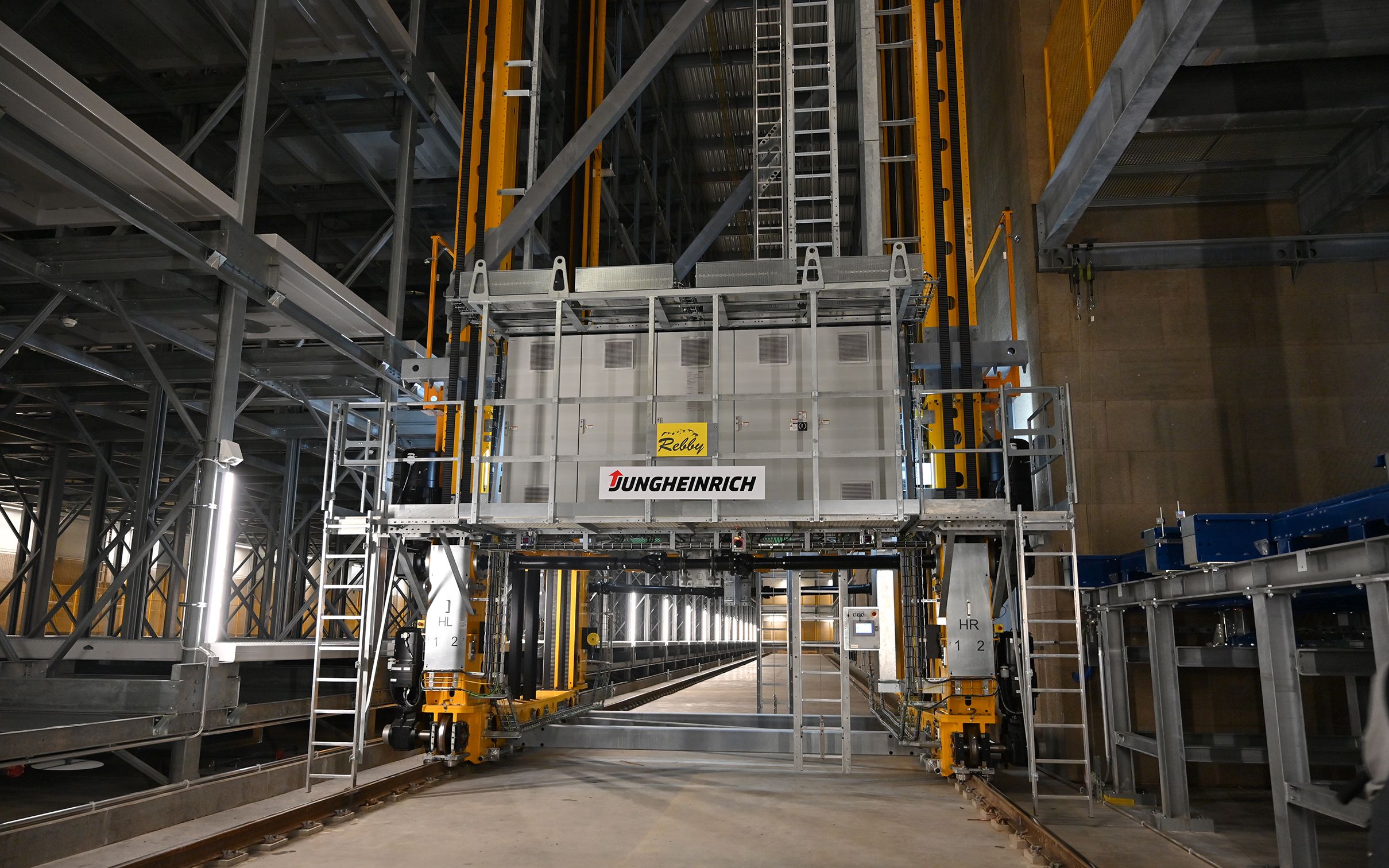 Il magazzino container completamente automatizzato costituisce il cuore dell'edificio. Qui i container vengono distribuiti automaticamente nei posti di stoccaggio previsti tramite un trasloelevatore. Dietro questo sistema si nasconde una programmazione complessa e unica nel suo genere.